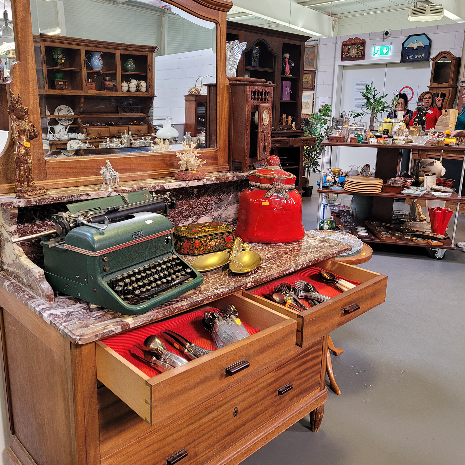 Intérieur de la boutique avec une étagère ancienne, une machine à écrire et divers objets de décoration décorationvintageGenève articlesdemaisond'occasion brocanteGenève secondevieobjetsGenève achatsolidaireGenève boutiquesecondemainGenève donnerobjetsGenève cadeausolidaireGenève décod’occasionGenève RenfileGenève