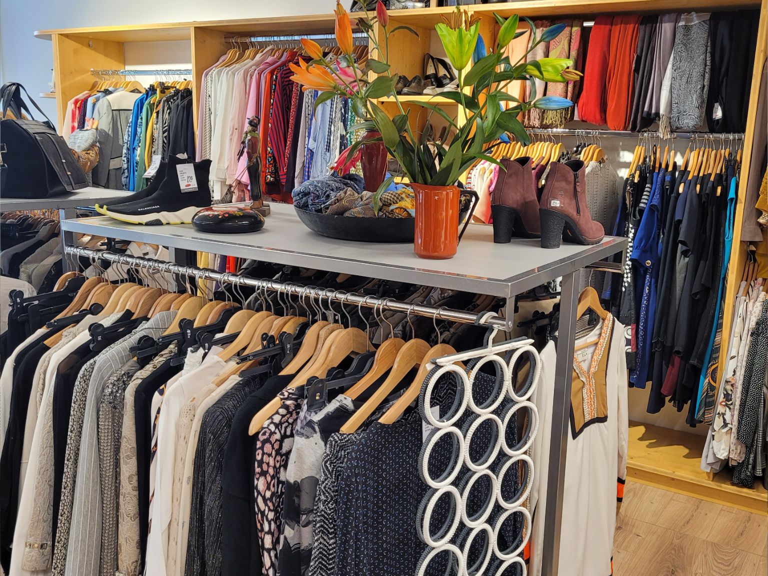 Vue intérieure de la boutique présentant des vêtements suspendus prêts à la vente vêtementssecondemainGenève friperieGenève boutiquesecondemainGenève magasinvintageGenève donnervêtementsGenève achatsolidaireGenève modedurableGenève secondevievêtementsGenève économiecirculaireGenève donsolidaireGenève